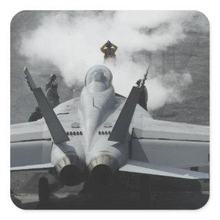 A flight deck director signals an F/A-18F Square Sticker