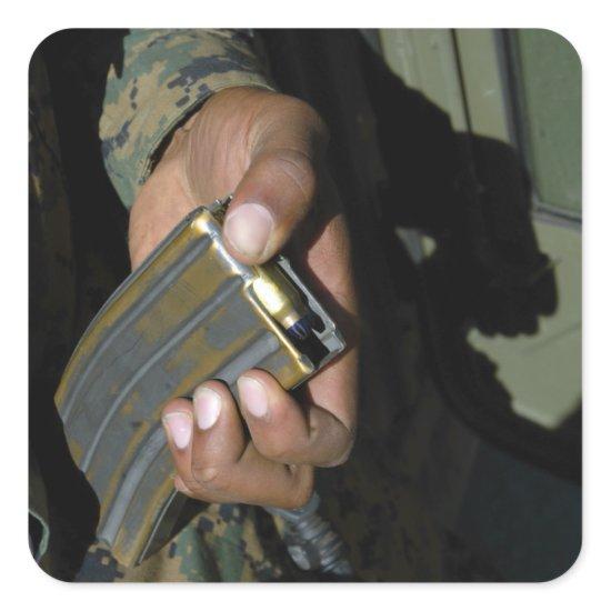 A Marine loads blank ammunition rounds Square Sticker