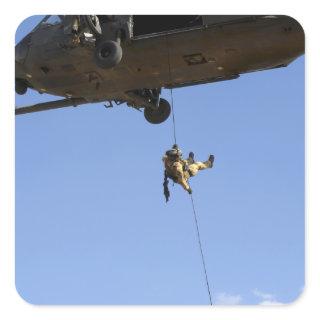 A pararescueman rappels from an HH-60 Square Sticker