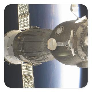 A Soyuz spacecraft backdropped by Earth Square Sticker