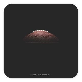 American football ball on black background square sticker