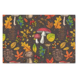 Autumn mushrooms, leaves, nuts and berries on dark tissue paper