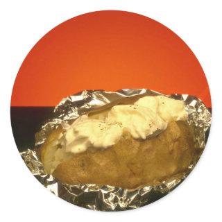 Baked potato with sour cream, against orange backg classic round sticker