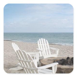 beachfront house with adirondack chairs and square sticker