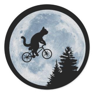 Cat is riding bicycle on the moon background. classic round sticker