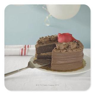 Chocolate cake with missing slice on table, square sticker