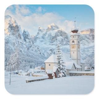 Church covered in snow with mountain background square sticker