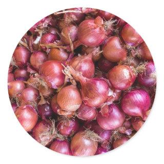 Heap of red onions on market classic round sticker