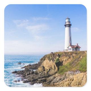 Lighthouse on hill blue sky white house ocean square sticker
