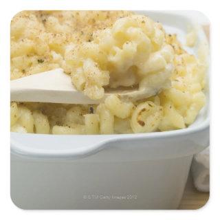 Macaroni cheese in baking dish with wooden square sticker