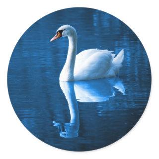 Pretty white swan floating on a blue lake classic round sticker