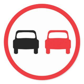 Round sticker with no overtaking traffic sign.