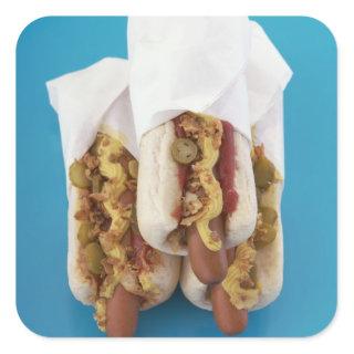 Three hot dogs in buns square sticker
